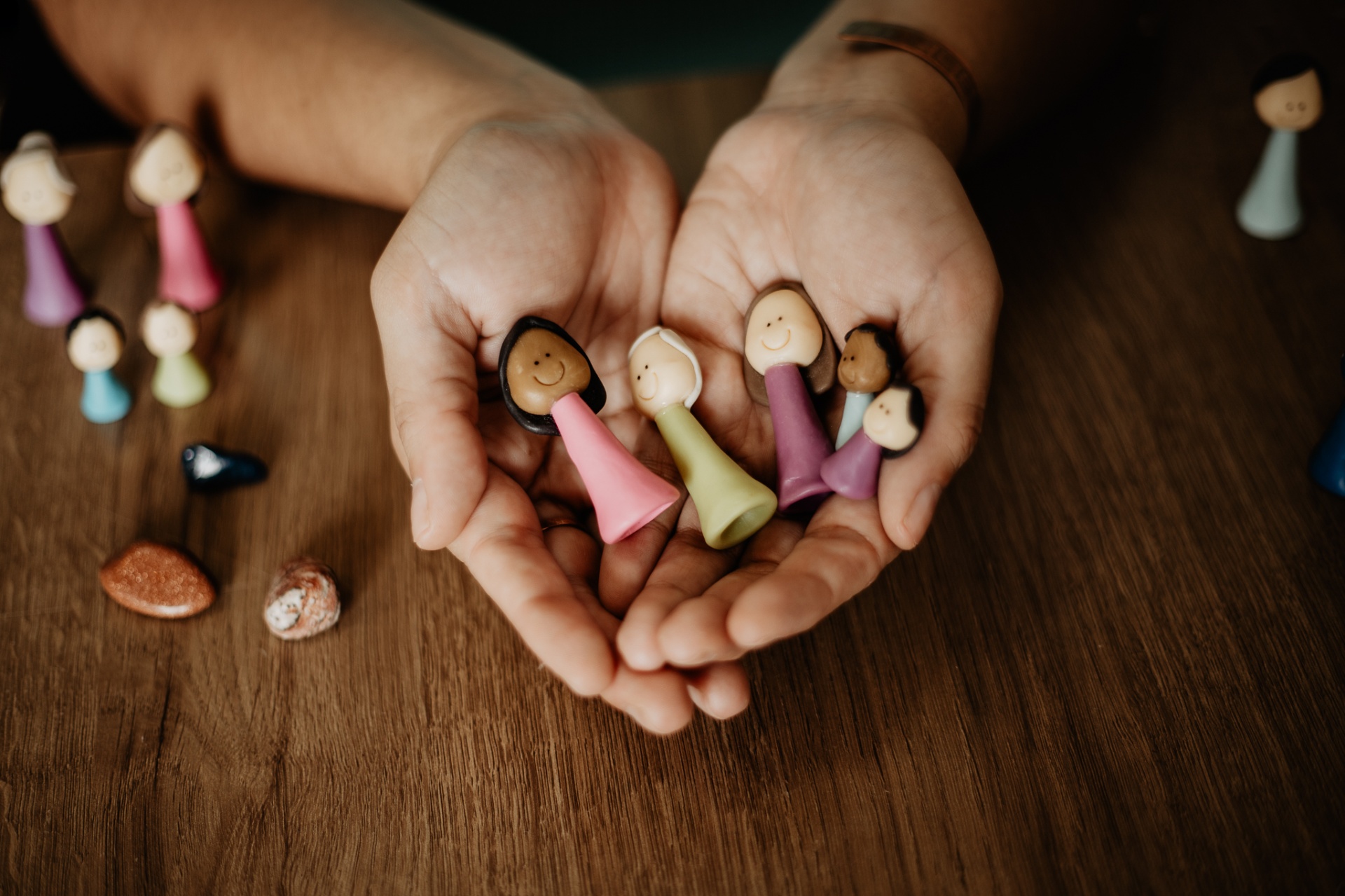 Mãos segurando bonecos artesanais — Saberes Integrativos